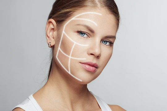 Close-up of attractive young female with light lines on her face. Concept of skin treatment, face rejuvenation and plastic surgery. 