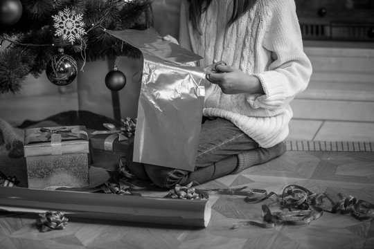 Closeup monochrome image of girl preparing Christmas gifts