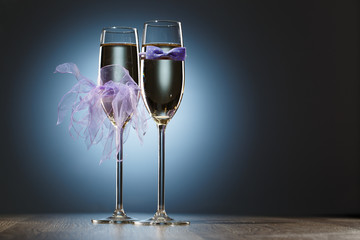Champagne glasses decorated purple bow-tie and veil for honeymooners