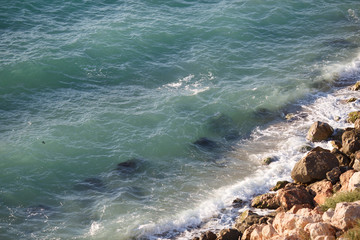Waves lapping on large coastal rocks