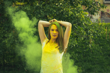 Beautiful brunette woman with exploding green dry powder