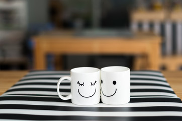Two happy cups on the table, about love concept