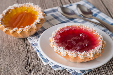 Pastry baskets.   Pastry baskets with fruit jam on a checkered napkin on gray wooden table.