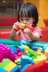 Asian Chinese little girl building blocks at indoor playground