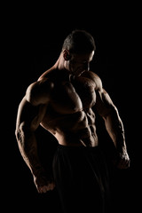 Fototapeta na wymiar torso of attractive male body builder on black background.