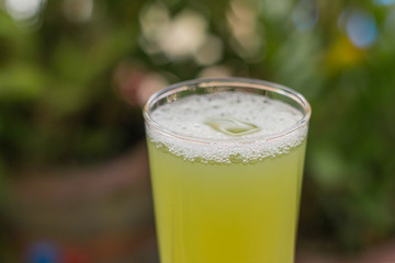 Sugarcane juice with piece of sugarcane on wooden background
