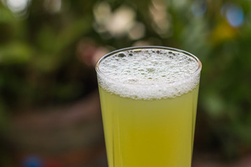Sugarcane juice with piece of sugarcane on wooden background