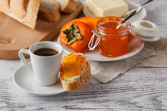 Breakfast with persimmon fruit jam and coffee on wooden table