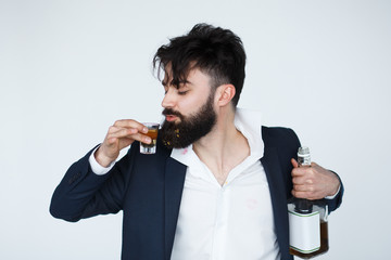 Drunk man with messy hair drinking whiskey