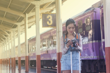 Backpack and camera at the train station with a traveler