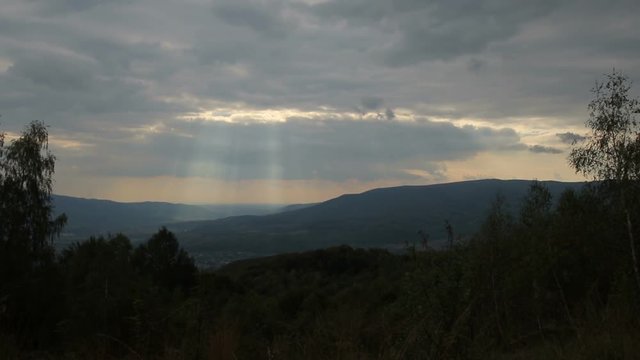 Mountain landscape with sunset sky and light breaking through the clouds (1080p, 25fps)