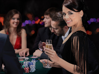 Poker players sitting around a table at a casino