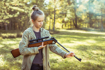 Girl shooting from the air rifle in the forest © Room 76 Photography