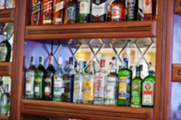 Peel and stick wallpaper Bar Blur efferct of several types of bottled alcohol are displayed o
