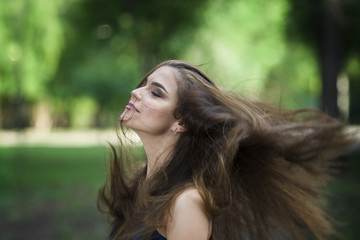 Naklejka premium Portrait of a beautiful young caucasian woman with flying long hair, clean skin and casual makeup