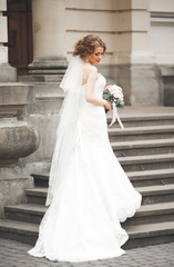 Obraz premium Wonderful bride with a luxurious white dress posing in the old town