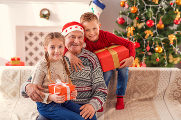 Happy old man with his grandchildren on Christmas