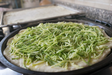 preparation of pizza with zucchini
