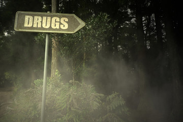 old signboard with text drugs near the sinister forest