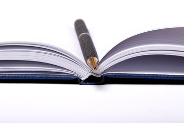 black ballpoint pen lying on a notebook