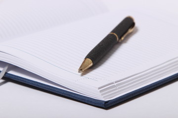 black ballpoint pen lying on a notebook