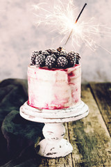 Birthday cake with sparkler on wooden vintage table