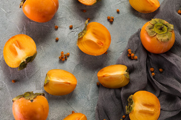 Delicious orange persimmons on wooden table .