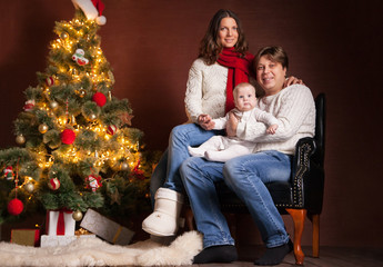 Happy family near Christmas tree at home