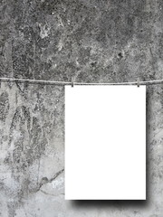 Single blank frame hanged by pegs against dirty concrete wall background