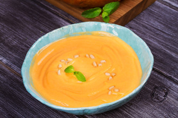 Bowl of pumpkin soup and  whole pumpkin. Butternut squash cream soup
