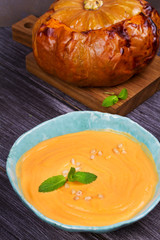 Bowl of pumpkin soup and  whole pumpkin. Butternut squash cream soup
