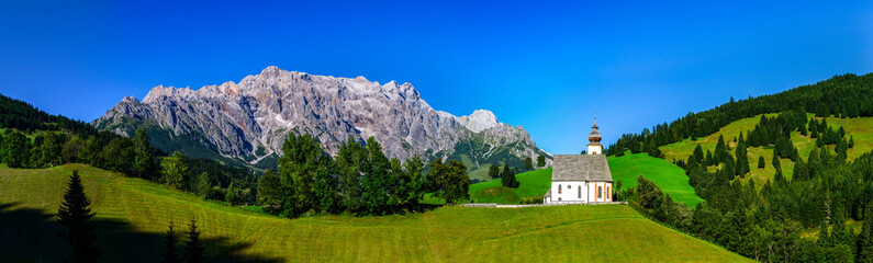 Fototapeta na wymiar Alps panoramic landscape view with a little church