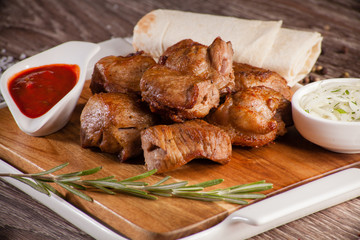 pork skewers on a wooden board in a white dish with pickled onio