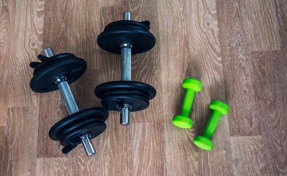 Bodybuilding concept. Two couple of dumbbells for men and women