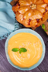 Bowl of pumpkin soup and  whole pumpkin. Butternut squash cream soup. View From Above, Top Studio Shot