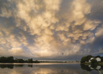 Stunning dramatic mammatus clouds formation over lake landscape