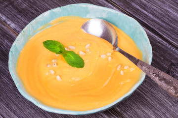 Bowl of pumpkin soup and  whole pumpkin. Butternut squash cream soup