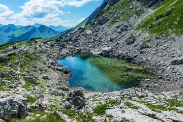Naklejka na ściany i meble Scenic view of clear pool of water atop mountain