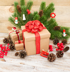 Fototapeta na wymiar Christmas or New Year background: fur-tree, branches, gifts, colored glass balls, decoration and cones on wooden background