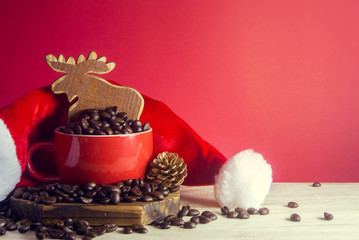 Obraz na płótnie Canvas coffee beans in cup with wood deer and near the pine cone with santa hat