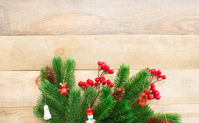 Christmas or New Year background: fur-tree, branches, gifts, colored glass balls, decoration and cones on wooden background