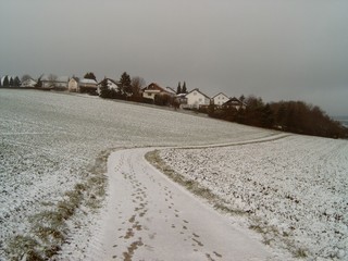 Fototapeta na wymiar Schnee und Häuser - Feld