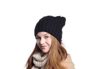 Girl in winter coat, scarf and hat, studio shot, isolated.