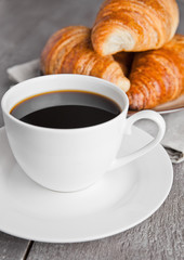 Cup of black coffee and croissant for breakfast