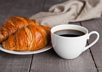 Cup of black coffee and croissant for breakfast