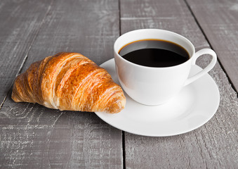 Cup of black coffee and croissant for breakfast