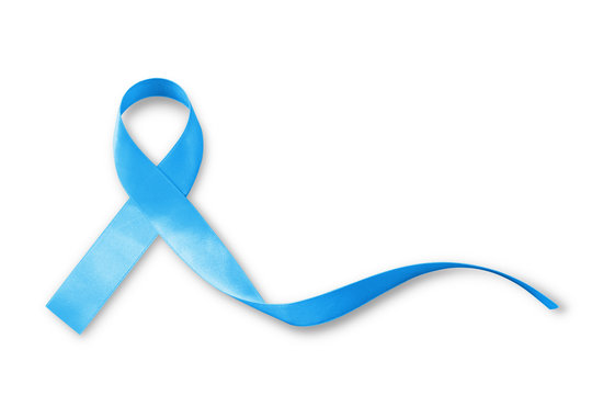 Light blue ribbon symbolic sign for prostate cancer awareness campaign and men's health in November isolated on white background: Shiny blue satin texture textile on dark wooden backdrop
