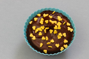 Close up of sweet homemade chocolate cupcakes with frosting on top with sugar sprinkles. Selective focus. 