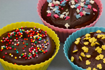 Close up of sweet homemade chocolate cupcakes with frosting on top with sugar sprinkles. Selective focus. 