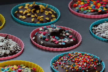 Close up of sweet homemade chocolate cupcakes with frosting on top with sugar sprinkles. Selective focus. 